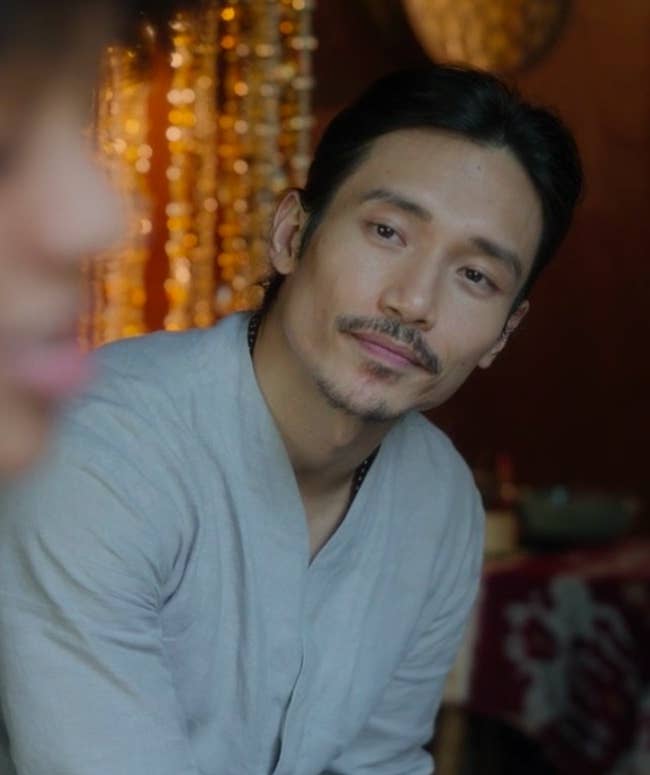 Yao looks at Delilah, who is out of focus, with affection