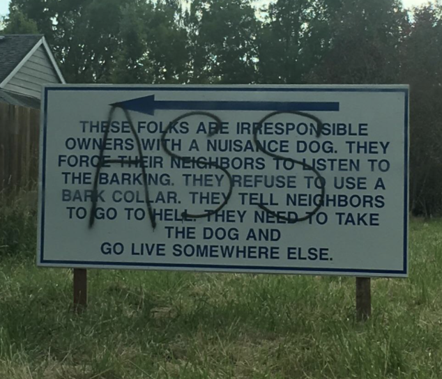Close-up of sign talking about neighbors who are &quot;irresponsible owners with a nuisance dog&quot; because &quot;they force their neighbors to listen to the barking,&quot; with &quot;ASS&quot; written across it in large letters