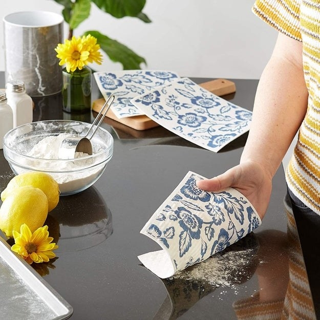 Model using a blue and white linen dish cloth to clean a counterModel using a blue and white linen dish cloth to clean a counter