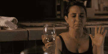 Woman with wine glass touches her heart