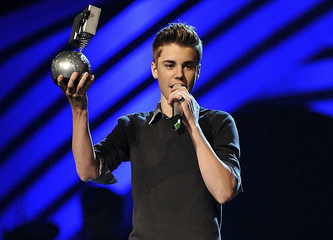 Justin Bieber holding his Moon Man on stage at the 2011 MTV VMAs