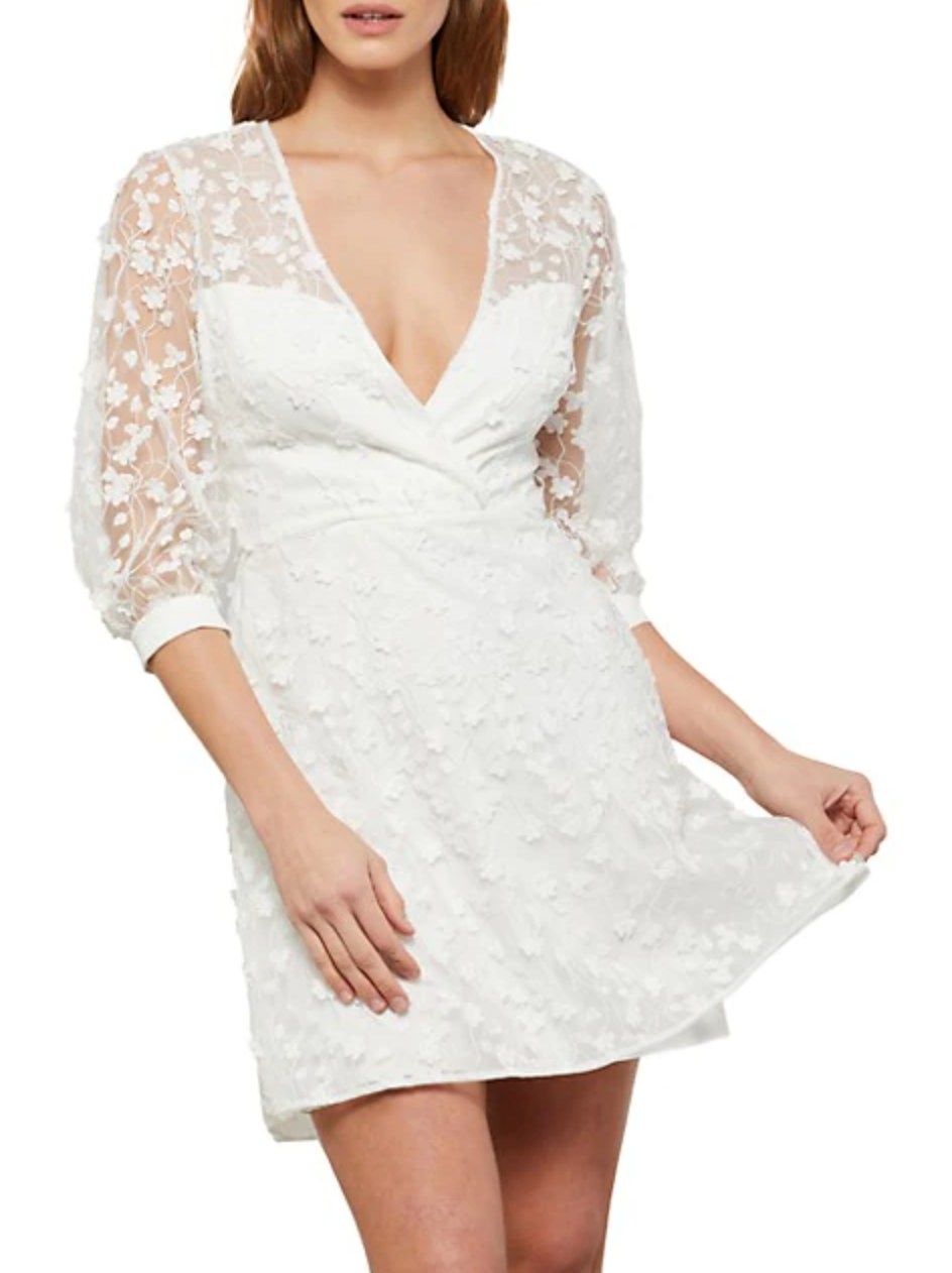 model wearing the dress in white with flower lace half-sleeves and v-cut neckline