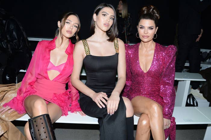 Lisa, Amelia, and Delilah pose for photos in the front row of a fashion show