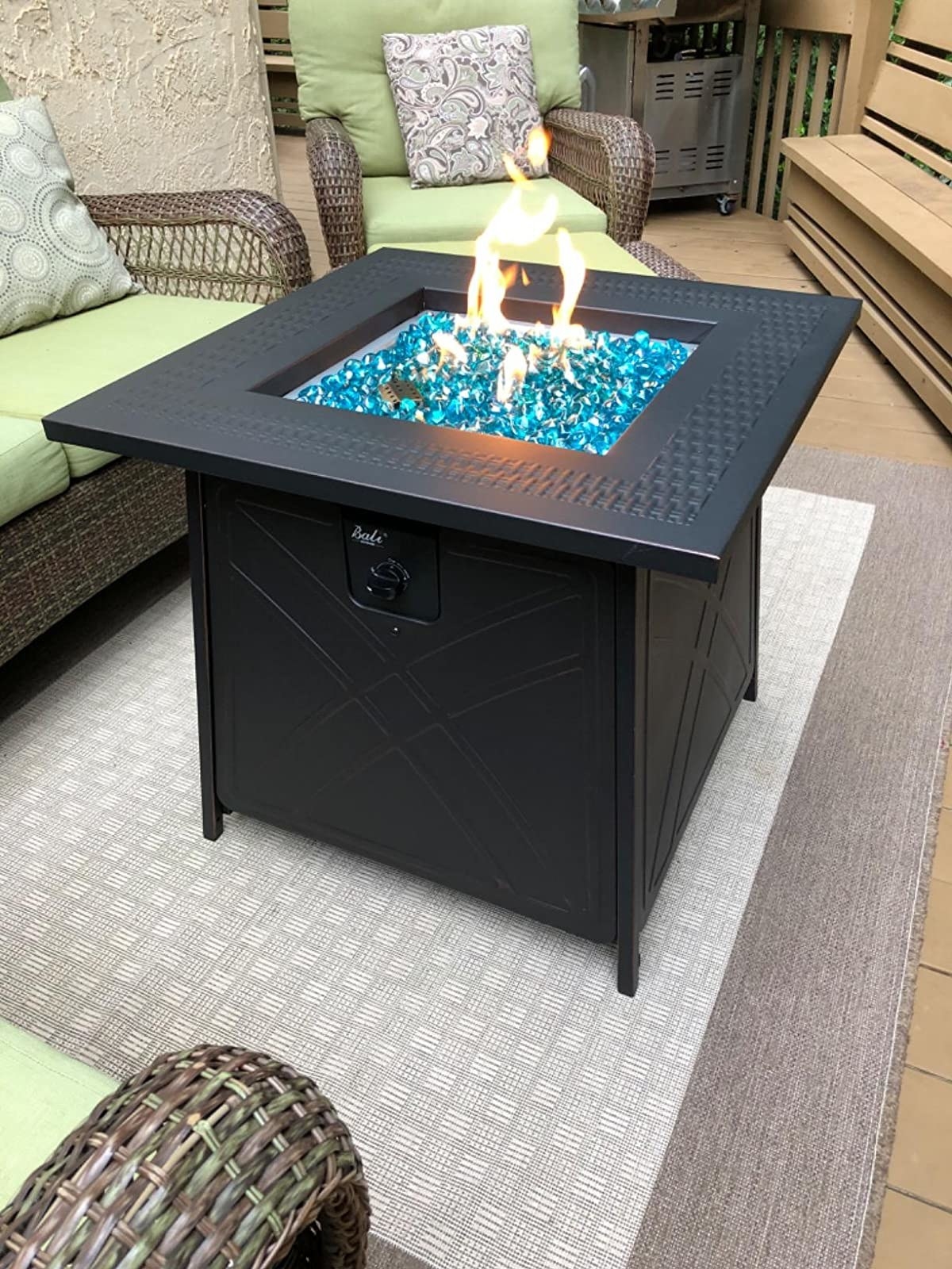 reviewer's fire pit lit up on their patio