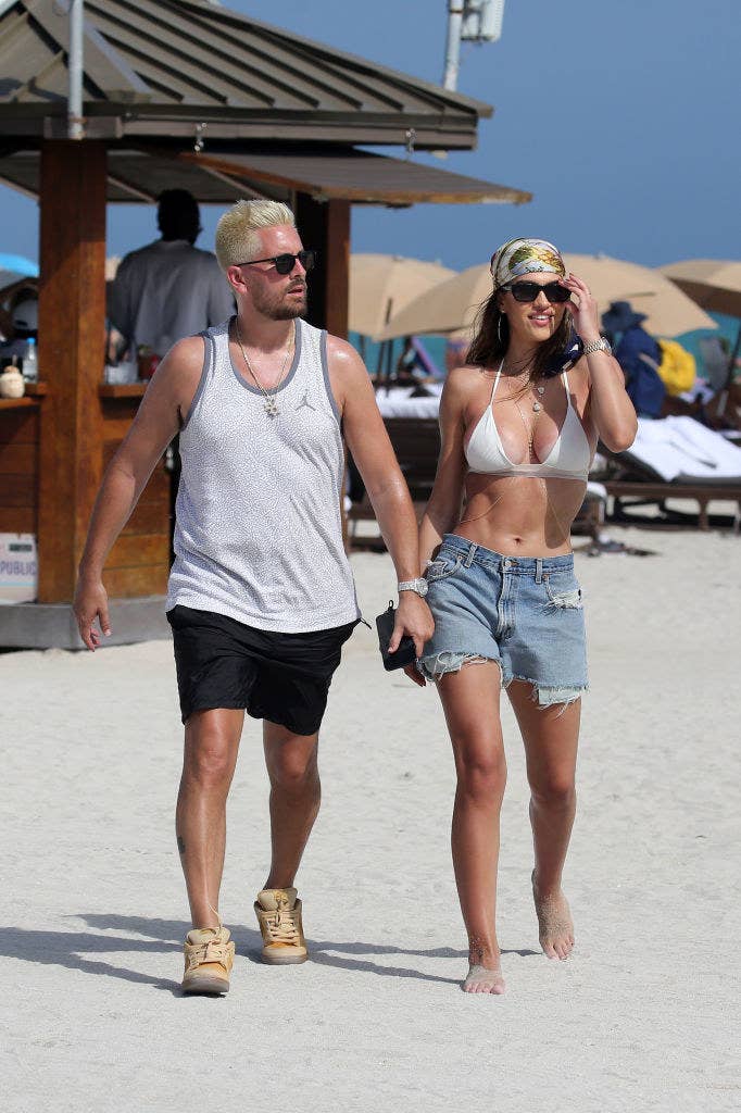 Scott and Amelia walking on a beach hand-in-hand