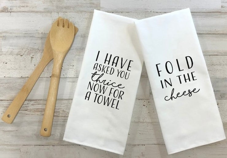 a pair of tea towels that say &quot;I have asked you thrice now for a towel&quot; and &quot;fold in the cheese&quot;