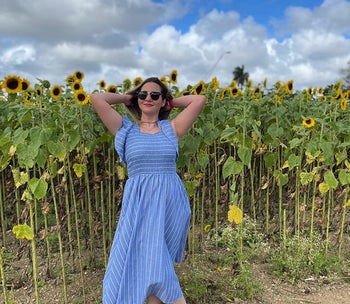 another reviewer wearing the dress in a sunflower field with white oxfords