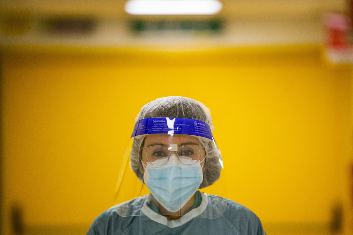 Doctor wears face mask and clear protective shield