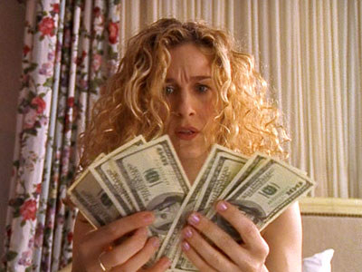 Carrie from sex and the city holding a bunch of money looking concerned
