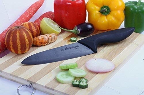 Chef&#x27;s knife kept on top of a chopping board beside vegetables
