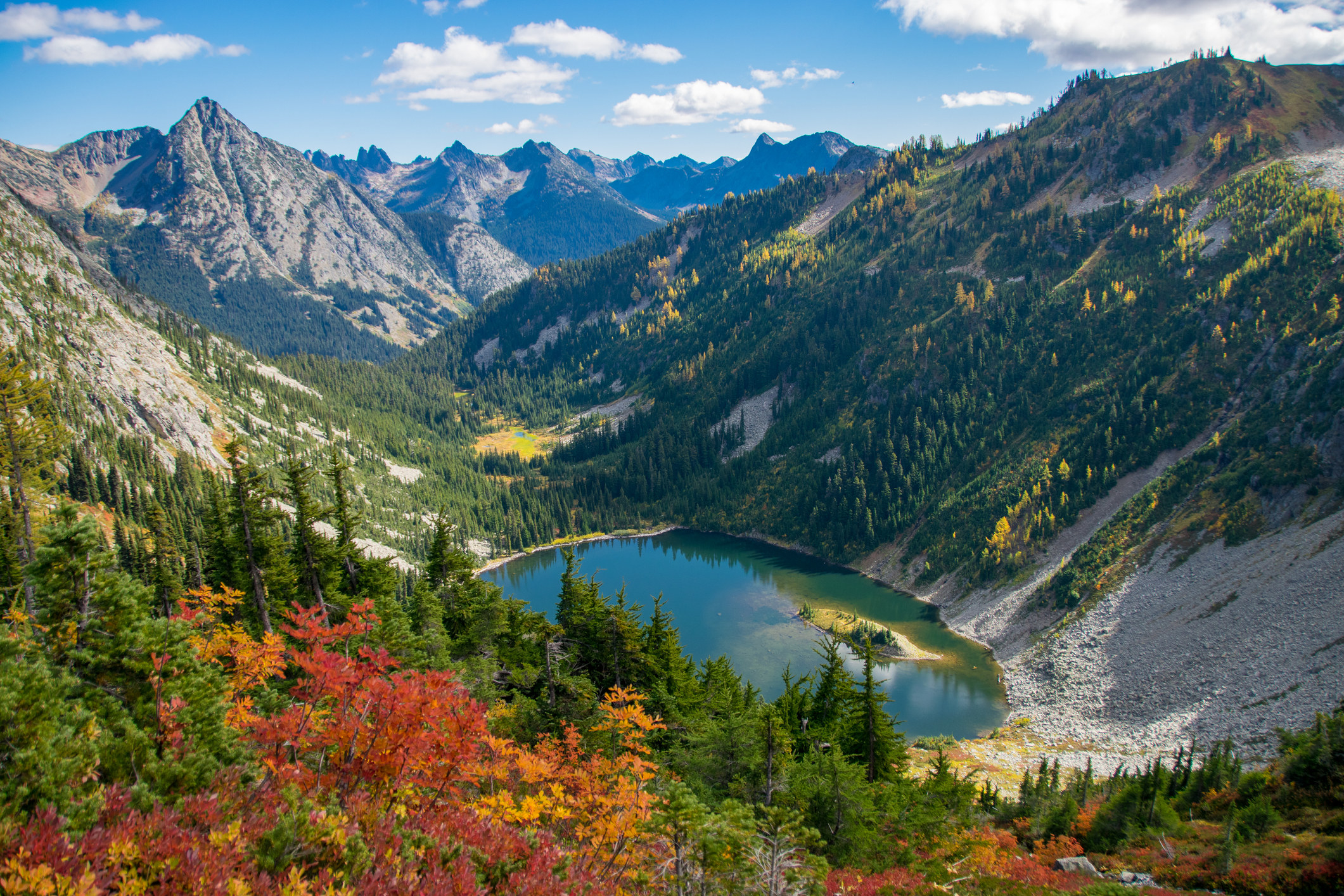 Looking down on beautiful Lake Ann surrounded by colorful fall foliage in Washington&#x27;s North Cascades in autumn.