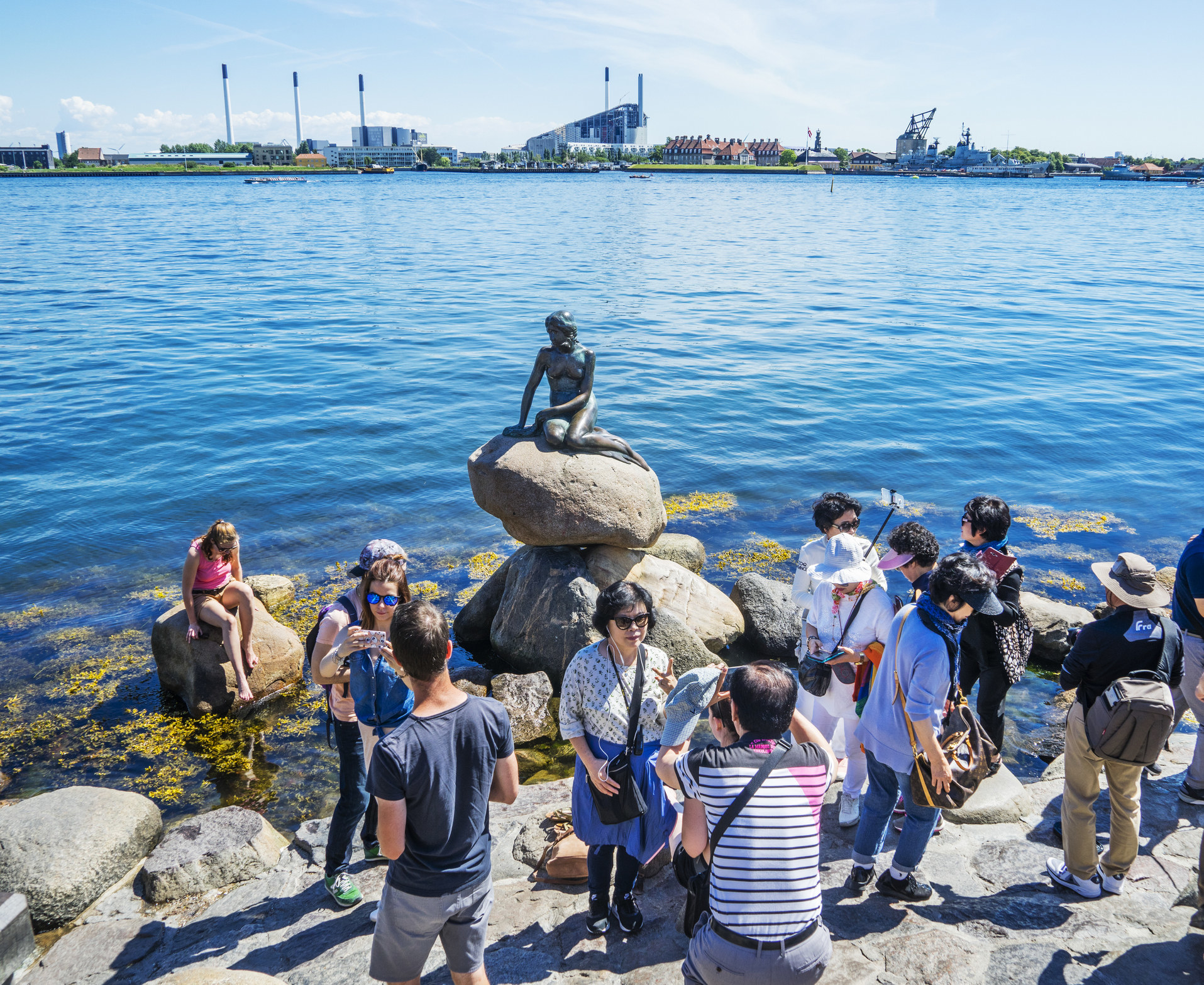 Tourists gathering around the Little Mermaid statue in Copenhagen