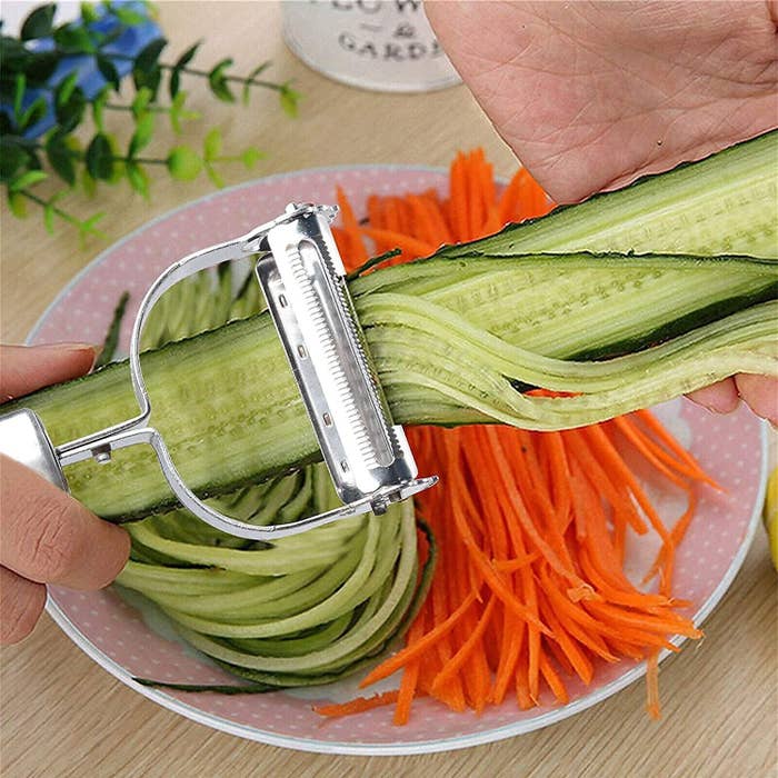 Julienne peeler being used to cut carrots and cucumbers