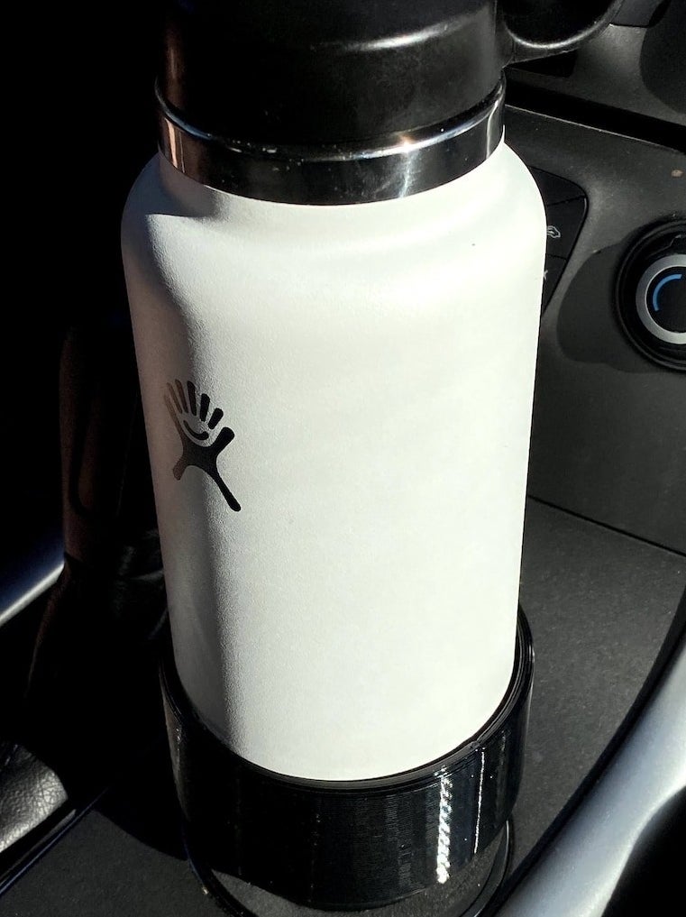 The adapter in someones cup holder holding a water bottle