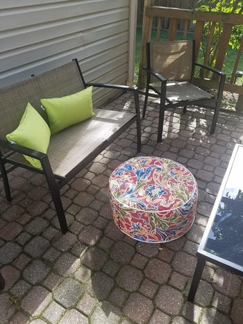 a reviewer photo of a patio chair with a printed ottoman in front to it