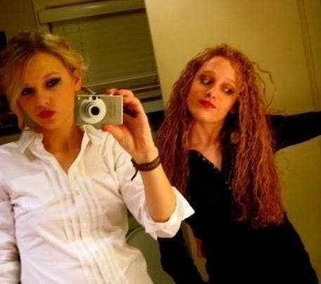 Taylor Swift taking a mirror selfie with a friend