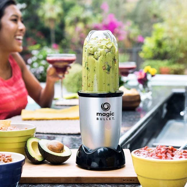 the magic bullet with guacamole and a person in the back