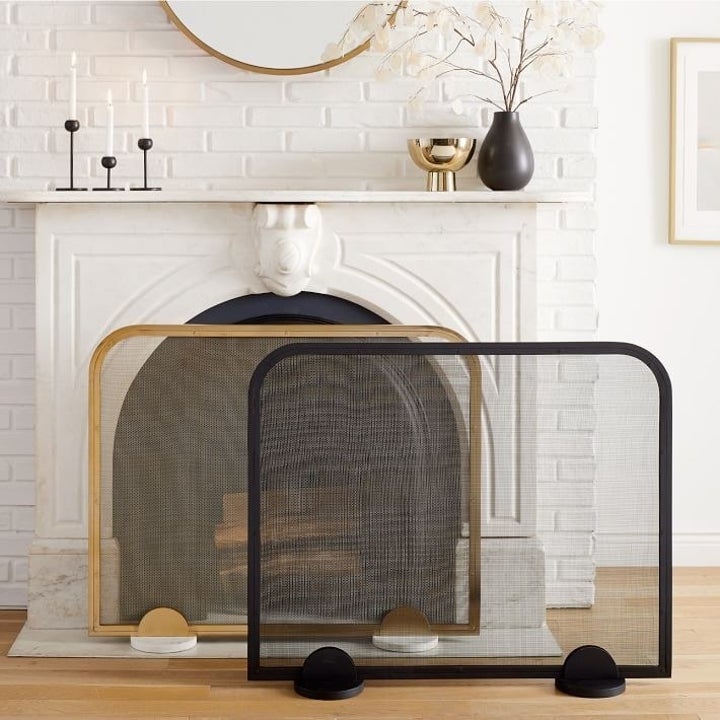 two screen covers for a fireplace. one with a gold frame and marble feet and another in all black.