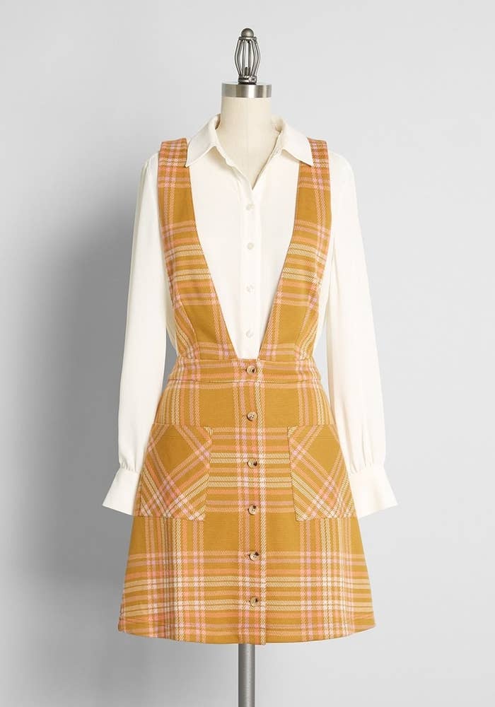 A yellow plaid overall dress with a white undershirt