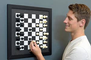 Model playing the magnetic chessboard attached to the wall