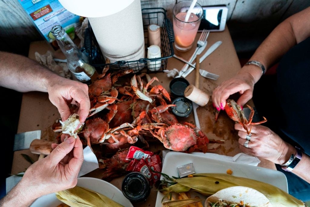 Two people sitting at a table and eating crab