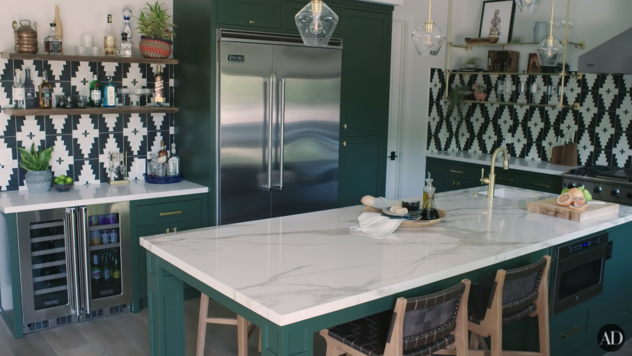 A dark-green kitchen with an island