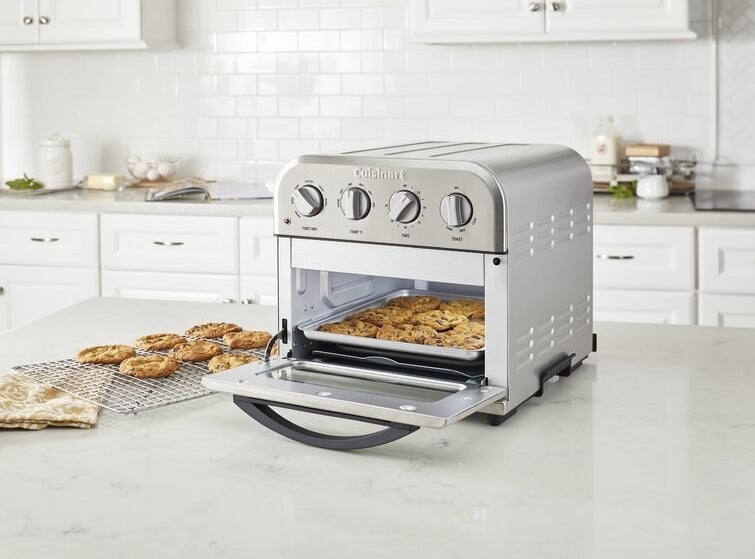 chocolate chip cookies being baked in the little oven on a counter