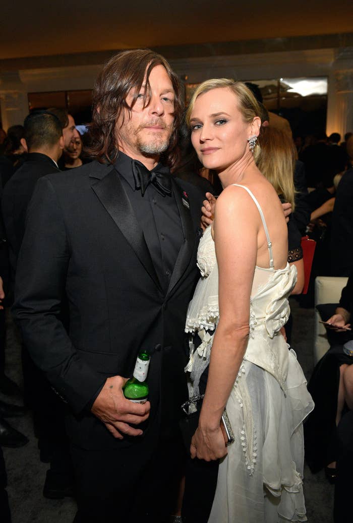 Reedus holds a beer while standing next to Kruger at an event