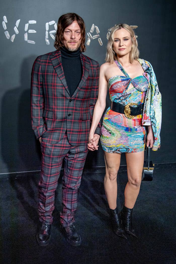 Norman Reedus and Diane Kruger pose for a photo on the red carpet while holding hands