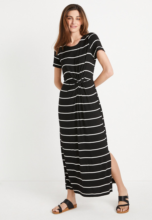 A model wears the black dress with white stripes with flat sandals