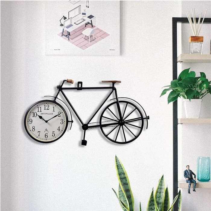 A wooden bicycle with a wall clock adorning its front wheel