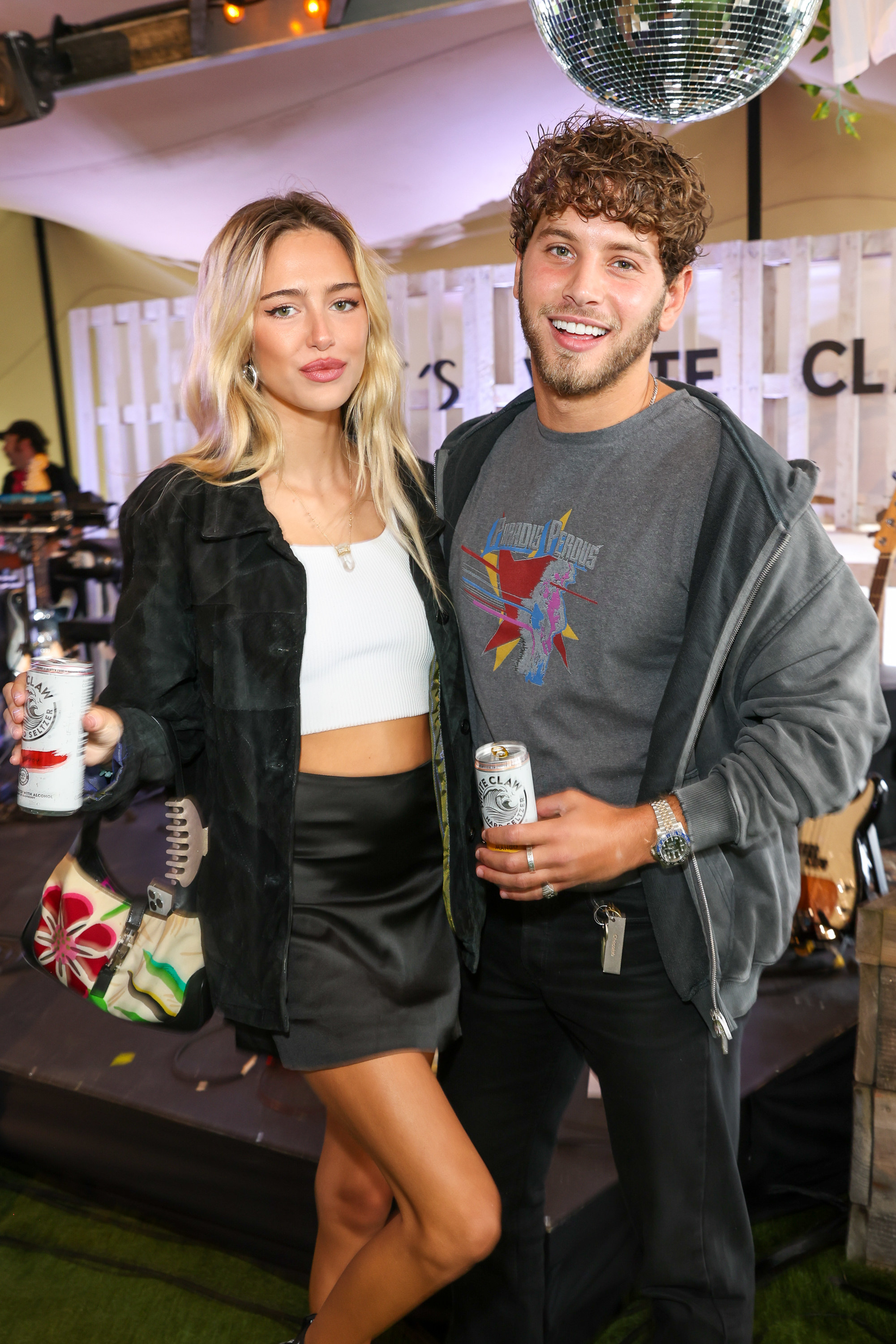 Delilah and Eyal posing for a photo while holding White Claws