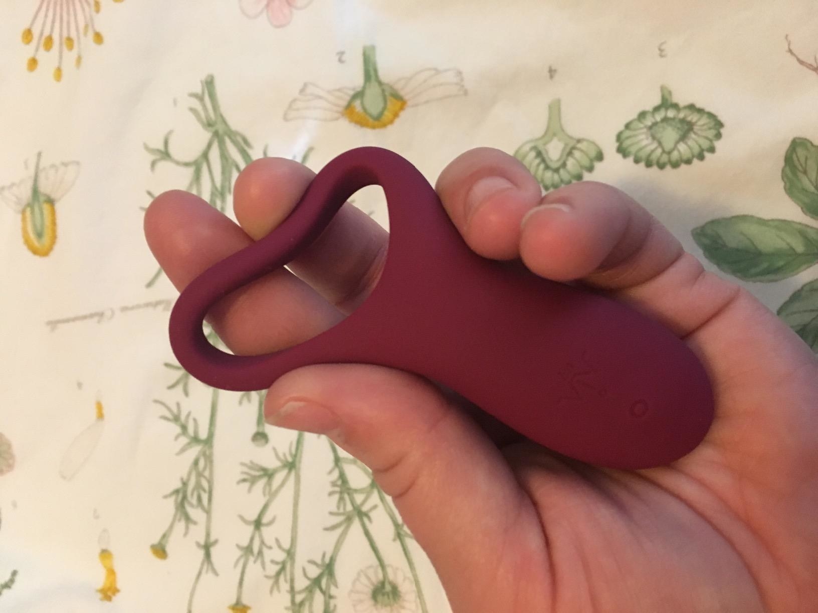 Model squeezing cock ring to show stretch