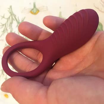 Model holding pink cock ring to display ribbed base