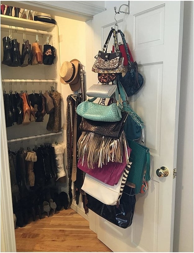 the hanger holding around 15 purses from the back of a closet door