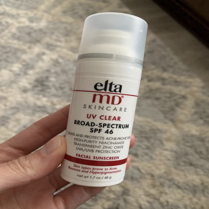 reviewer holding bottle of sunscreen