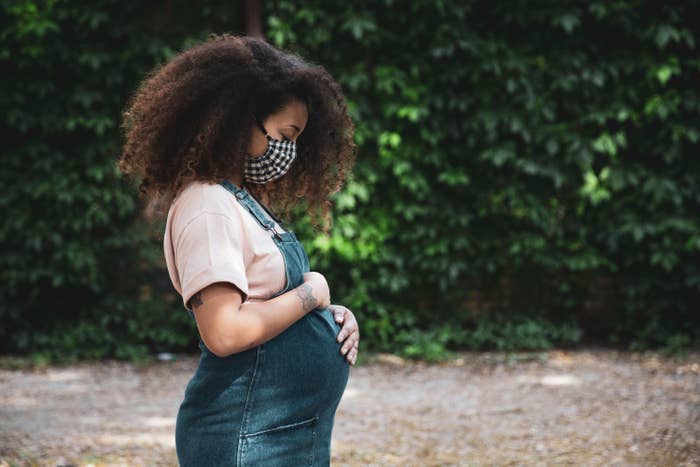 An image of a pregnant woman cradling her belly