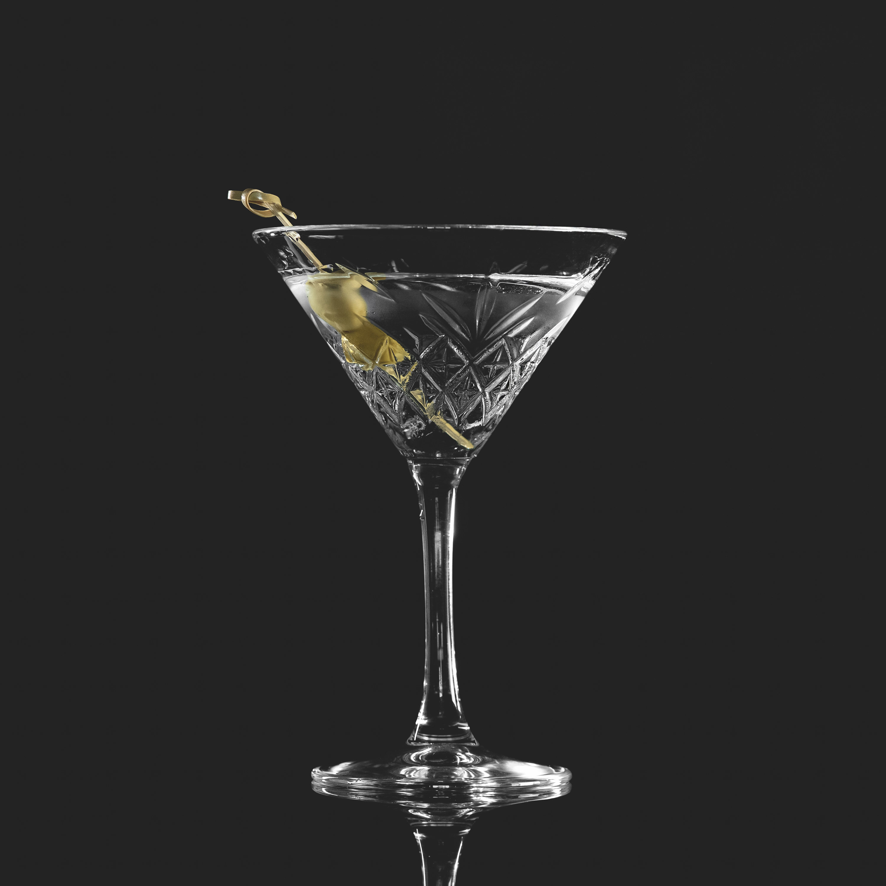 Martini in a glass with olives on toothpick