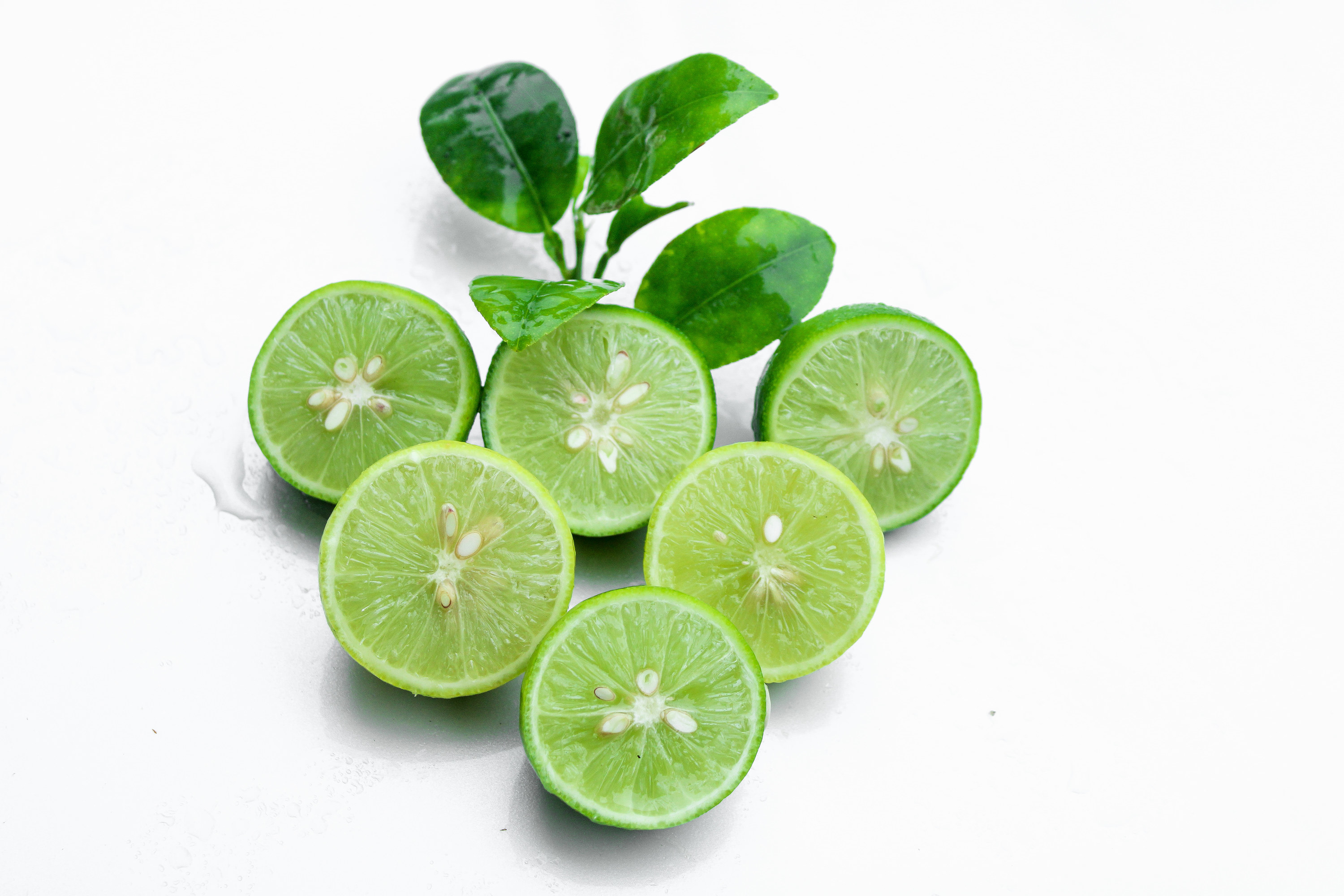 Six lime halves arranged in a triangle, cut-sides out