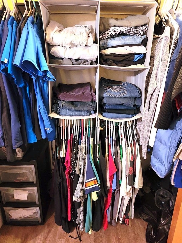 reviewer&#x27;s closet with the hanging organizer packed with clothes and folded clothes
