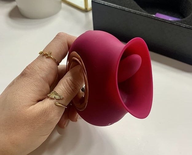 Model holding red vibrator to display tongue-like detail