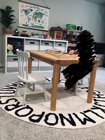 Reviewer's photo showing the black and white alphabet round rug in their kid's room