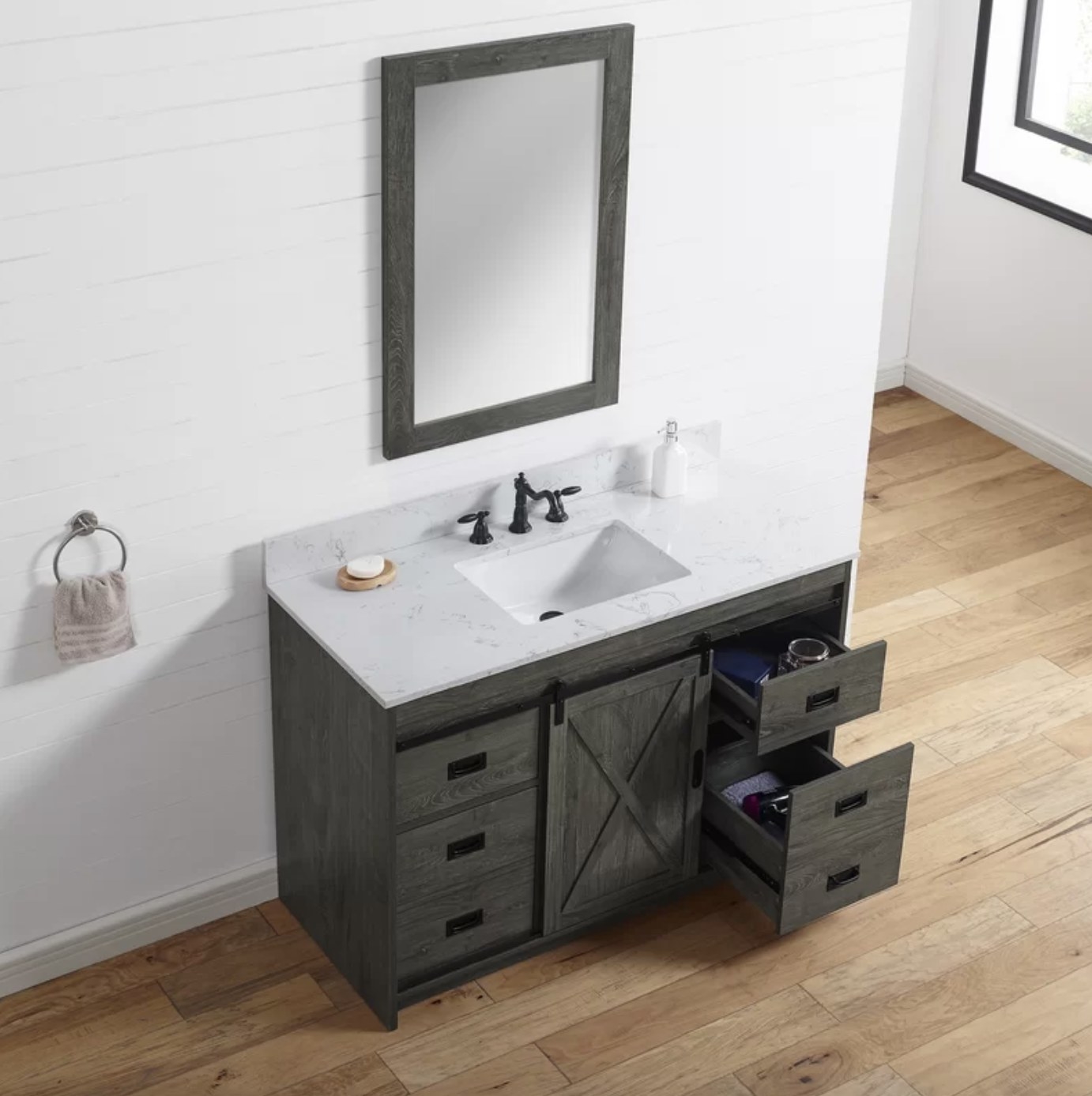 The sink has a marble styled white top and six charcoal grey drawers split between a barn-style door