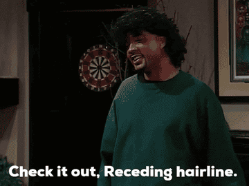 John Henton playing lead character Overton Jones slwoly pulling off a curly wig from his bald head.