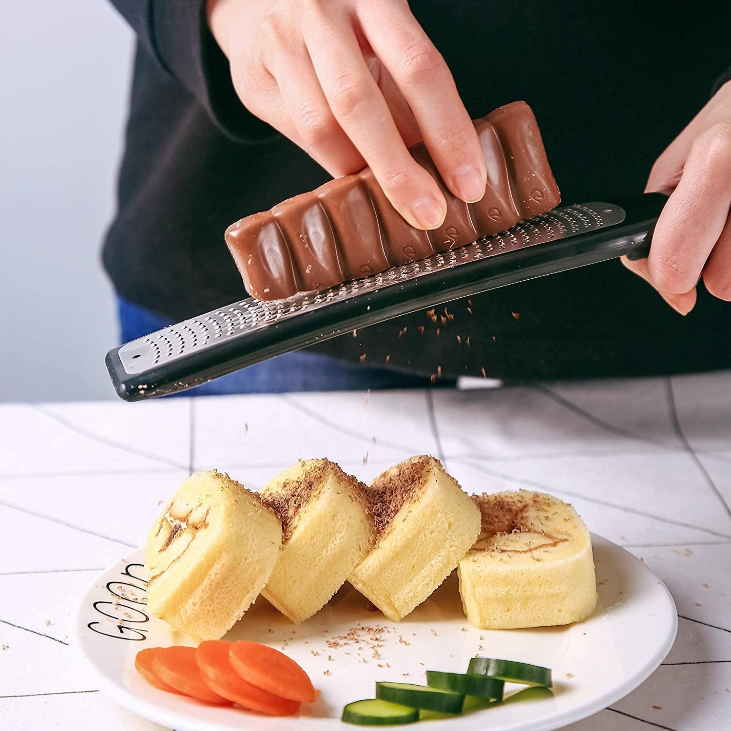 A person using the microplane to grate chocolate
