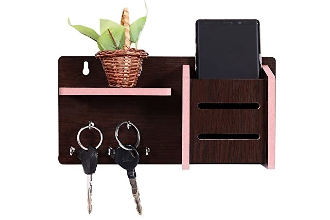 The mail organiser has a key hooks, a small shelf with a plant on it, and a slot with a phone in it
