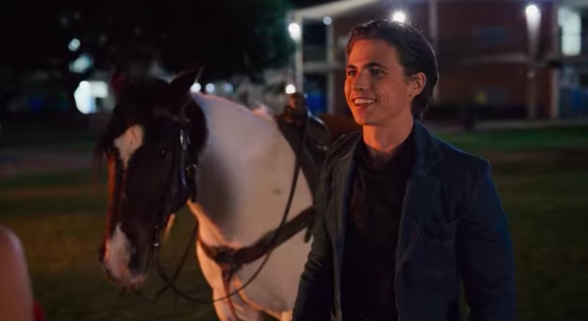 Cameron smiles while standing in front of a horse