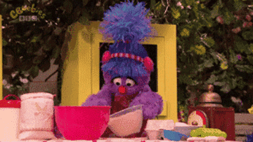Cookie Monster and two other muppets cooking with mixing bowls