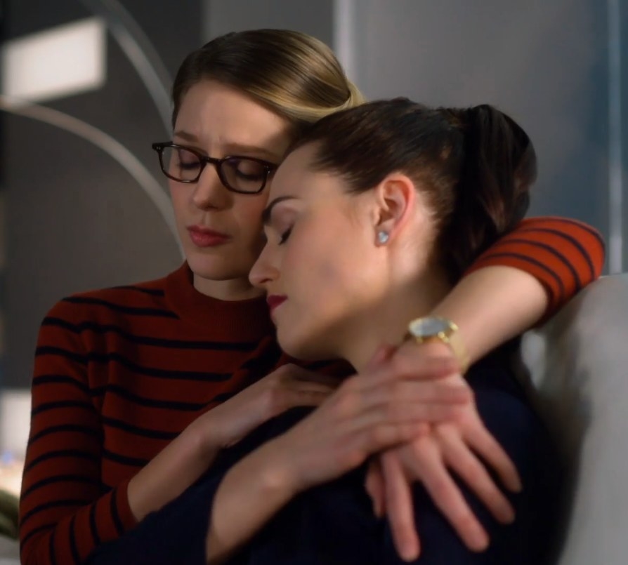 Kara sits with her arm around Lena&#x27;s shoulders as they cuddle on a couch