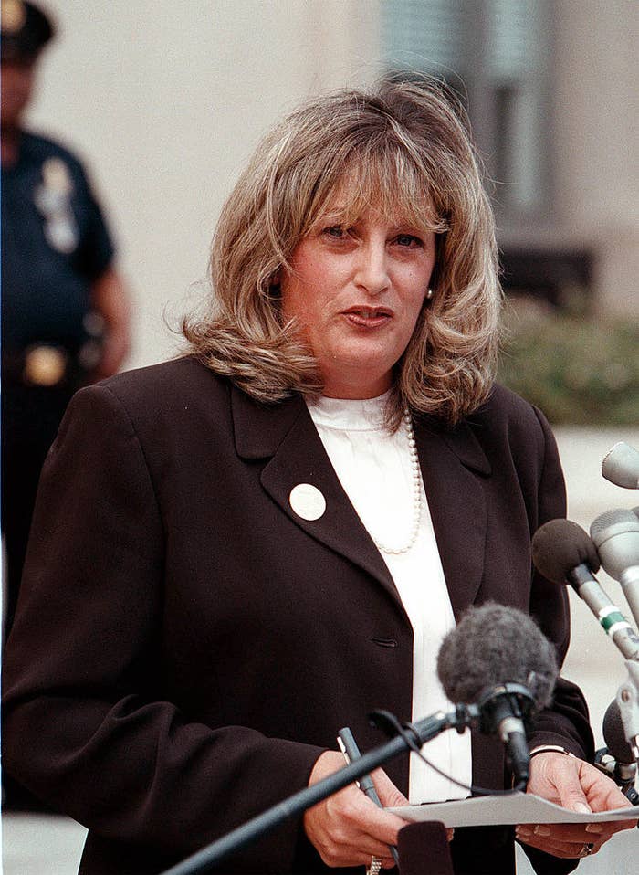 Linda Tripp speaking into several microphones